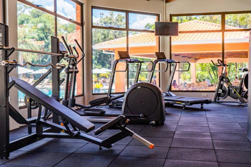 a gym with several treadmills and elliptical machines at Sanma Hotel in Foz do Iguaçu