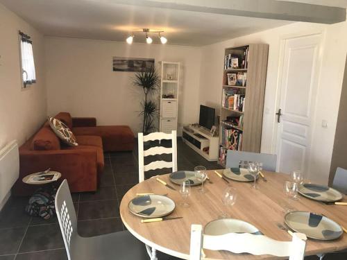 une table à manger et des chaises dans un salon dans l'établissement Maison avec piscine au calme, à Puygiron