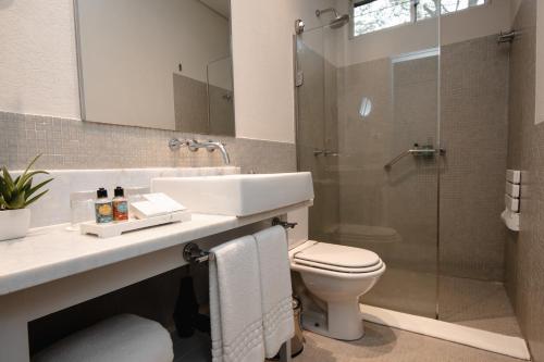 a bathroom with a sink and a toilet and a shower at Sanma Hotel in Foz do Iguaçu