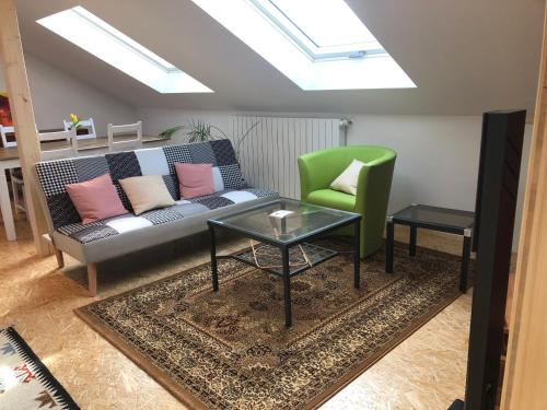a living room with a couch and a green chair at Haus Waldeck in Ühlingen-Birkendorf