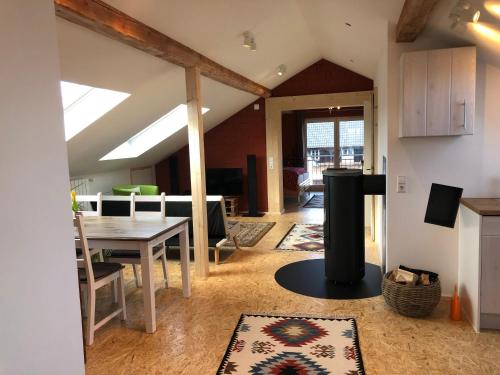 a kitchen and living room with a table and a fireplace at Haus Waldeck in Ühlingen-Birkendorf
