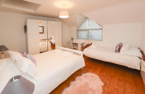 a bedroom with two beds and a window at Two bedroom townhouse in the heart of Dungarvan in Dungarvan