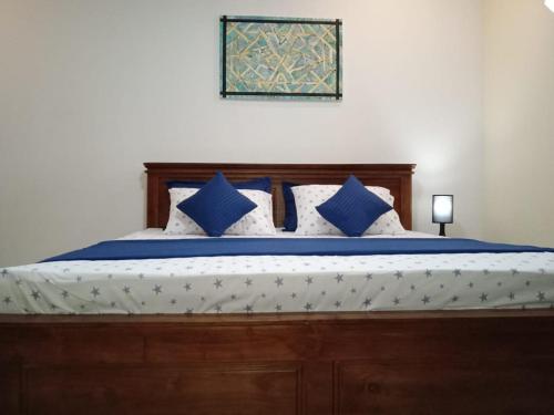 um quarto com uma cama com almofadas azuis e brancas em Friendly home stay em Etagama