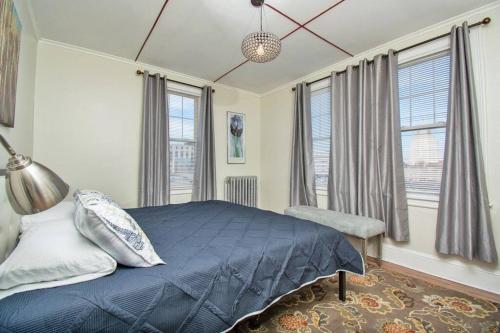 a bedroom with a blue bed and windows at The Bushnell Suite C2 in Hartford