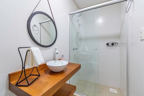 y baño con lavabo y ducha con espejo. en Villagio del Veneto - Stay House Temporada, en Canela