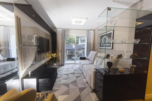 un salon avec un canapé et une table dans l'établissement Rosa Edifício Centro One, à Gramado