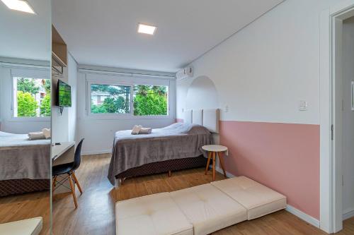 1 dormitorio con 2 camas, escritorio y 2 ventanas en Villagio del Veneto - Stay House Temporada, en Canela