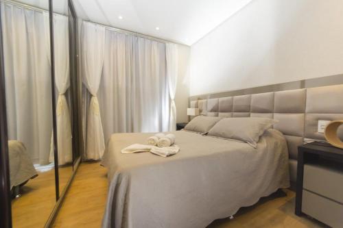 une chambre avec un lit avec des serviettes dessus dans l'établissement Rosa Edifício Centro One, à Gramado