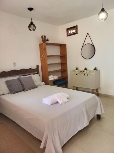 1 dormitorio con 1 cama grande y 2 toallas. en Cantinho Braslis Suíte linda e aconchegante em Caraiva, há 10 minutos da praia, en Porto Seguro