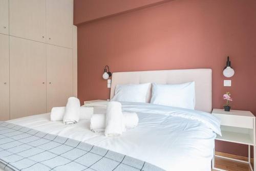 ein großes weißes Bett mit weißen Kissen im Schlafzimmer in der Unterkunft Pale Orb Properties (2) in Athen