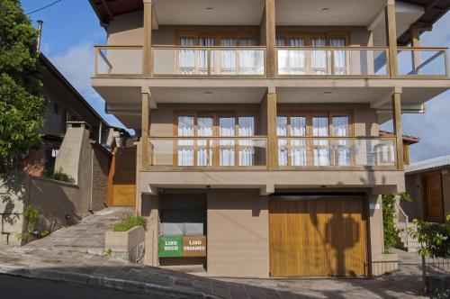 un gran edificio con balcón en una calle en Rosa Edifício Lés Residénce, en Gramado