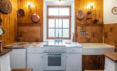 a kitchen with a white stove and a sink at Maison nonna Tilde - Valsusa in Mattie