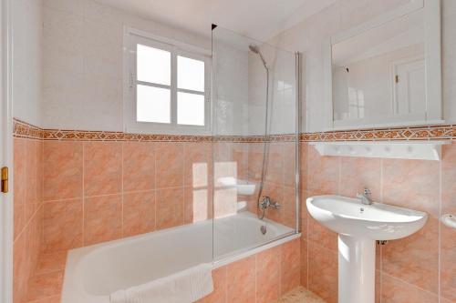 La salle de bains est pourvue d'une baignoire et d'un lavabo. dans l'établissement Bonita Casa Nina con Jacuzzi By Paramount Holidays, à Playa de San Juan