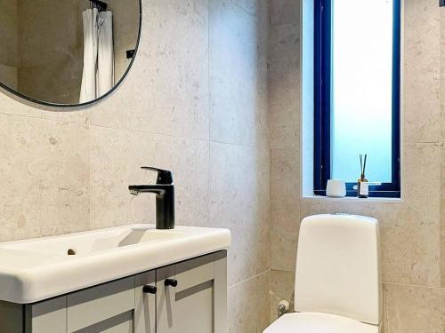 a bathroom with a sink and a toilet and a mirror at Holiday home HJÄRNARP III in Hjärnarp