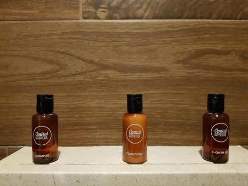 three bottles of soap sitting on a shelf at Historico Central Hotel in Mexico City