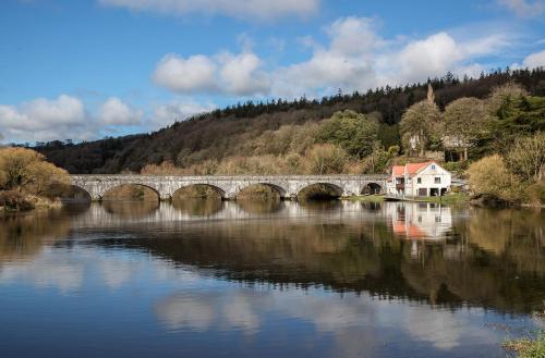 a bridge over a river with buildings and trees at Two bedroom townhouse in the heart of Dungarvan in Dungarvan