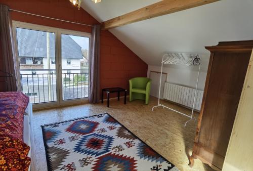 a living room with a green chair and a rug at Haus Waldeck in Ühlingen-Birkendorf