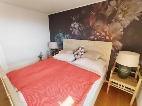 a bedroom with a large bed with a painting on the wall at Ferienhaus Herk am Sulzerweg - Deutschlandsberg in Deutschlandsberg