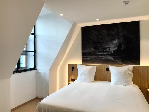 a bedroom with a large bed with white sheets at Comic Art Hotel in Ghent