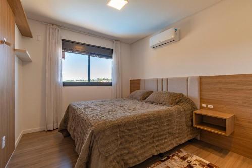 sypialnia z łóżkiem i oknem w obiekcie Rosa Edifício Volo Class w mieście Canela