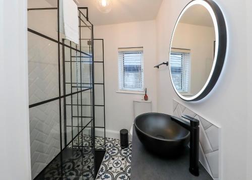 baño con bañera negra y espejo en Two bedroom townhouse in the heart of Dungarvan en Dungarvan