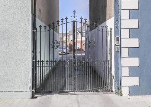 an iron gate in a building with a street behind it at Two bedroom townhouse in the heart of Dungarvan in Dungarvan