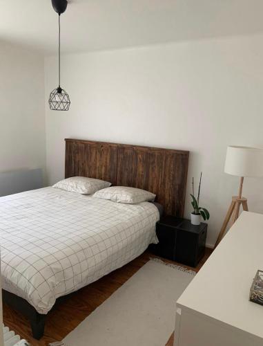 une chambre avec un lit avec une tête de lit en bois dans l'établissement Proche du centre ville avec parking privé gratuit, à Aix-en-Provence