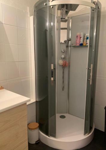 une douche avec une porte vitrée dans une salle de bain dans l'établissement Proche du centre ville avec parking privé gratuit, à Aix-en-Provence