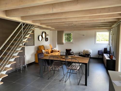 un salon avec une table et un escalier dans l'établissement CHALET DUPLEX CHARMANT ENTRE LAC ET MONTAGNES, à Dingy-Saint-Clair