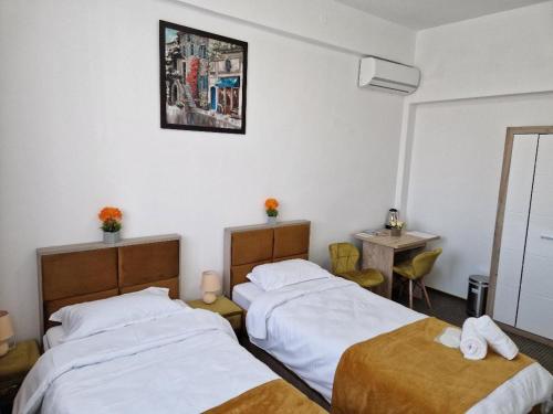 a bedroom with two beds and a table and a mirror at ANTIK HOUSE in Cornu de Jos