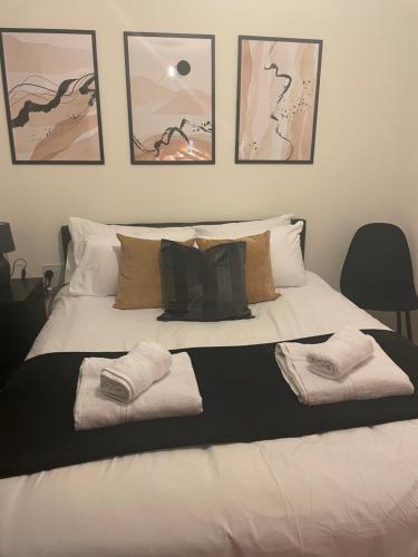 a white bed with three towels on top of it at Great 1Bed 10 mins from East Croydon with Free WiFi in Croydon