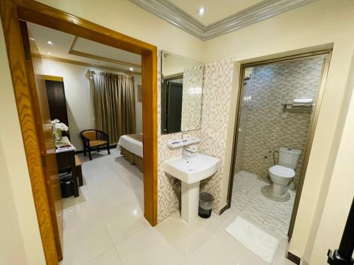 een badkamer met een wastafel, een douche en een toilet bij Diamond Tower in Al Jubail