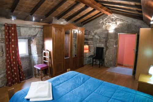 ein Schlafzimmer mit einem blauen Bett in einem Zimmer in der Unterkunft Casa do Lagar in Geres