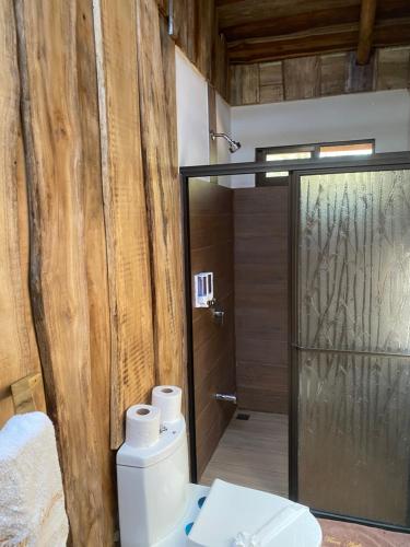 a bathroom with a toilet and a glass shower at Finca Avellanas in Playa Avellana