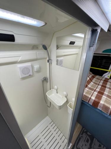 ein kleines Zimmer mit einem Waschbecken und einem Bett in der Unterkunft Autocaravana in Puerto de Sagunto