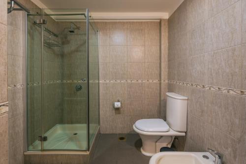 uma casa de banho com um WC e uma cabina de duche em vidro. em Belgrano R em Ushuaia