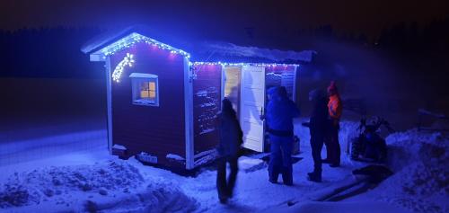 a group of people standing outside of a tiny house in the snow at Agroturystyka na Słonecznej Orawie u Dzikich in Jabłonka