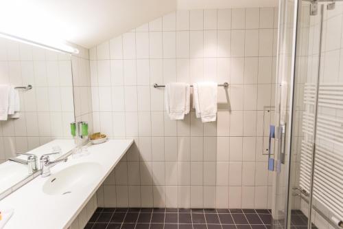 uma casa de banho com um lavatório e um chuveiro em Sorell Hotel Arabelle em Berna