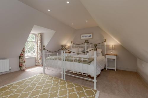 une chambre avec un lit blanc dans un grenier dans l'établissement Home Farm Cottage, à Stranraer