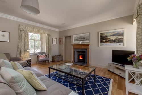 a living room with a couch and a fireplace at Home Farm Cottage in Stranraer