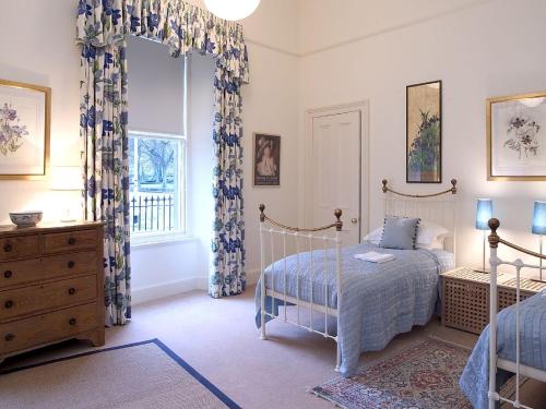 ein Schlafzimmer mit einem Bett, einer Kommode und einem Fenster in der Unterkunft 1 Bellevue Terrace in Edinburgh