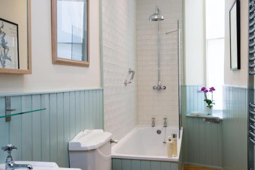 a bathroom with a tub and a toilet and a sink at 1 Bellevue Terrace in Edinburgh