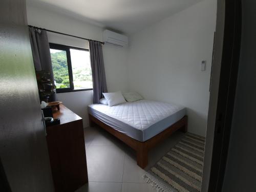 - une petite chambre avec un lit et une fenêtre dans l'établissement Villa MATOANUI, à Tevaitoa