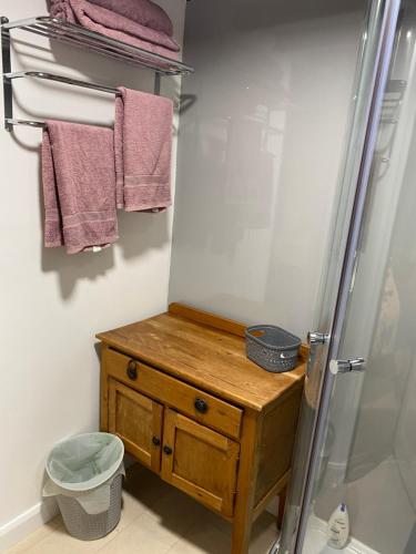 a bathroom with a shower and a wooden vanity and towels at The Barn at Providence Cottage in Alkborough