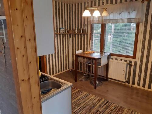 a kitchen with a sink and a table in it at Omakotitalo ykspihlajassa 110m2 in Kokkola