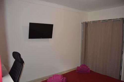 Habitación con TV de pantalla plana en la pared en 4 pièces à Nice - 20 min de la plage, en Niza