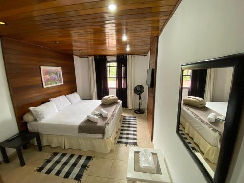 ペトロポリスにあるCasa Petrópolisのベッドルーム1室(ベッド2台、大きな鏡付)
