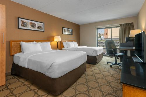 a hotel room with two beds and a television at Comfort Inn in Sydney