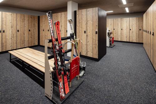 a room with skis and a bench in it at Sporthotel Obereggen in Obereggen