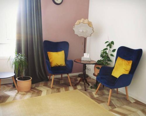 twee blauwe stoelen met gele kussens in de woonkamer bij Stuckverzierte, zentrumsnahe Wohnung im Süden in Leipzig